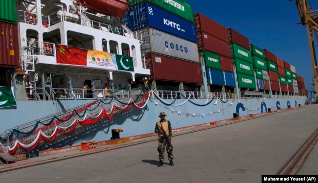 A security guard stands outside a ship at the port of Gwadar, which has been leased to a Chinese corporation by the Pakistani government.