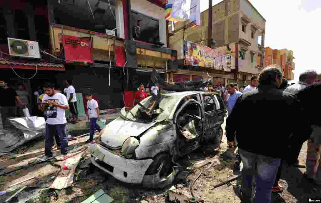 People gather at the scene of a car-bomb explosion outside a hospital in Benghazi, Libya. At least nine people were killed. (Reuters/Esam al-Fetori)