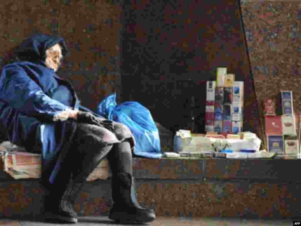 Financial crisis felt all over the world. - An elderly woman sleeps as she sells cigarettes to make some money in the center of Kiyv on October 24, 2008. Ratings agency Standard and Poors downgraded the credit standing of Ukraine on Friday on doubts about its ability to deal with a mounting financial crisis. 