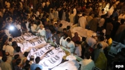 Pakistan -- Locals crowd around the bodies of the victims of a suicide bomb attack, at a hospital in Lahore, Pakistan, 02 November 2014. 