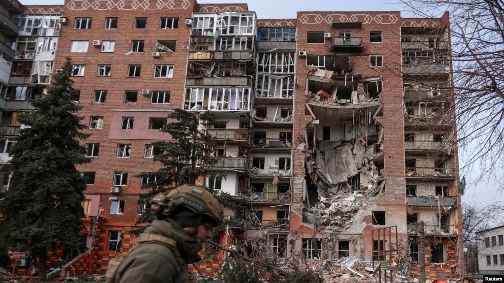 Украинский военный на фоне разрушенного при обстрелах жилого дома в Покровске (Донецкая область)