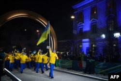 Владислав Гераскевич несе державний прапор України під час церемонї відкриття Олімпійських Ігор в Італії. 6 лютого 2026 року, Кортіна д’Ампеццо