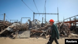 Работник возле объекта критической энергетической инфраструктуры, который был поражен во время ракетного удара России, Харьков, Украина, 10 апреля 2024 года