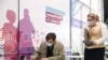 Мужчина заполняет листок информированного согласия на вакцинацию в прививочном пункте в торговом центре «Арена Плаза». Москва, апрель 2021 года