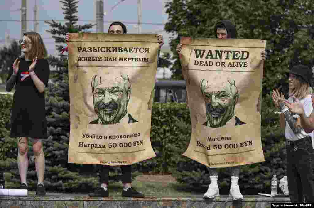 Protesters hold up posters with Belarusian President Alyaksandr Lukashenka standing near the entrance to a factory calling on workers to join a strike and protests in Minsk on August 18. (epa-EFE/Tatyana Zenkovich)