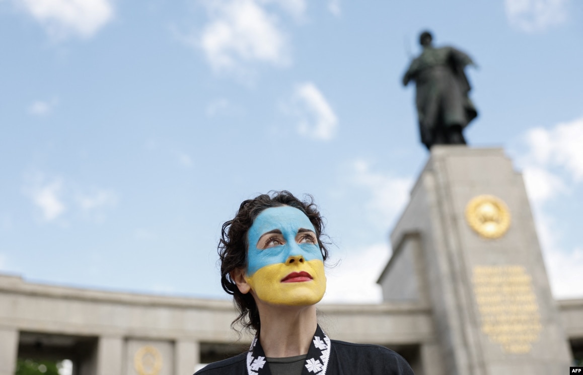 Солідарна з Україною жінка перед меморіалом радянським воїнам в Тіргартені в Берліні на 8 травня 2025 року, у 80-ту річницю завершення Другої світової війни в Європі