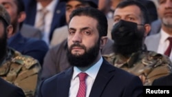 Санкції проти аш-Шараа, раніше відомого як Мухаммад аль-Джулані, запровадили 2014 року через те, що він очолював радикальне ісламістське угруповання «Джебгат ан-Нусра»