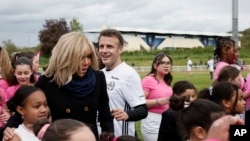 Președintele francez și soția sa, Brigitte Macron, pozează după ce el a jucat într-un meci de fotbal caritabil pentru un spital pentru copii, pe stadionul Bernard Giroux stadium din Plaisir, în apropiere de Paris, în luna aprilie 2024.