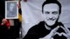 Жена държи свещ и портрет на Алексей Навални, който загина в руски затвор отвъд Полярния кръг преди 10 дни. Барселона, Испания, 25 февруари 2924 г.
