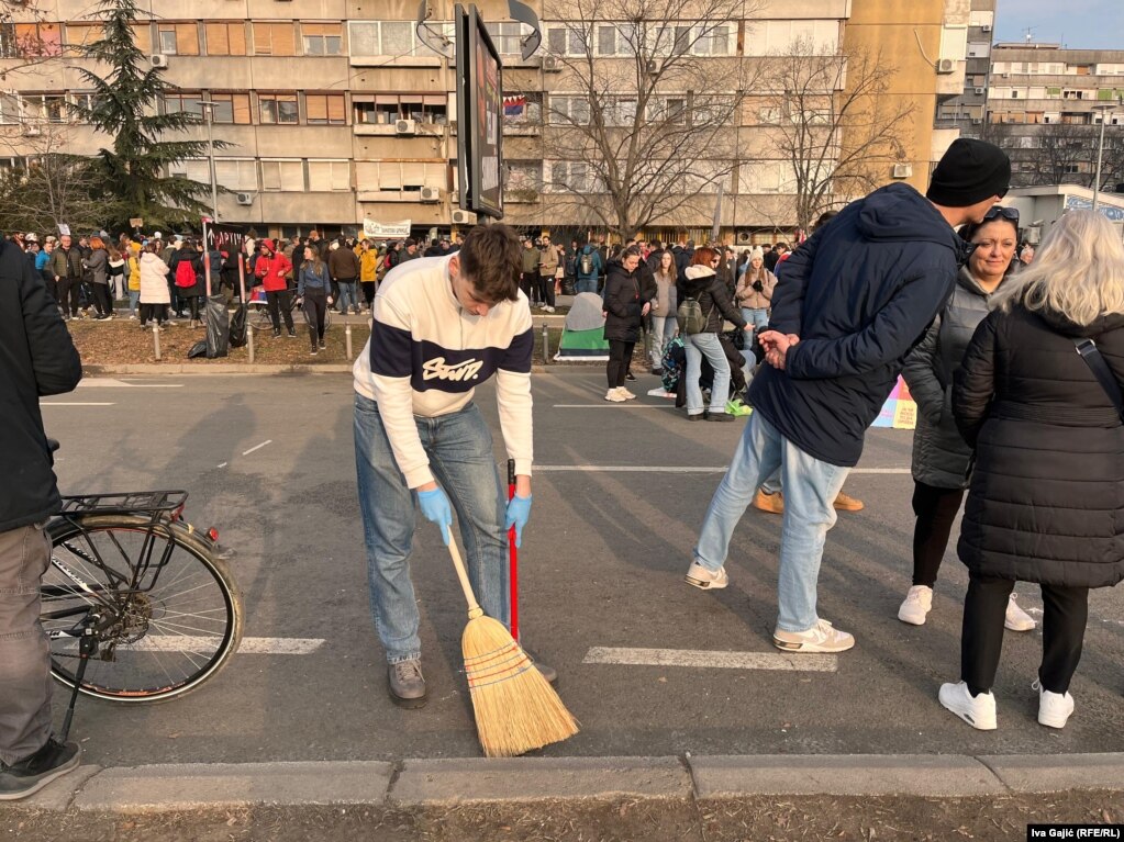 Një student pastron një rrugë që ishte e bllokuar për 27 orë gjatë protestës në Novi Sad, 2 shkurt 2025.