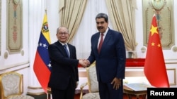 Тогдашний лидер Венесуэлы Николас Мадуро (справа) принимает китайского посланника Цю Сяоци в Каракасе 2 января 2026 года, за несколько часов до начала американской операции