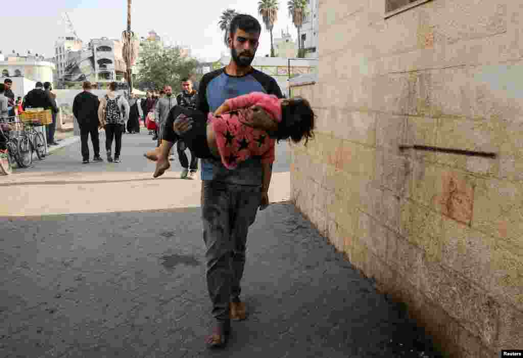 Un bărbat cară în brațe cadavrul unei fete palestiniene ucise într-un atac israelian asupra unei case din Jabalia, orașul Gaza, pe 10 noiembrie 2024.Campania militară israeliană în Gaza a ucis cel puțin 67.000 de persoane, conform cifrelor de la ministerul sănătății din teritoriul controlat de Hamas, cifre pe care Organizația Națiunilor Unite le consideră credibile.