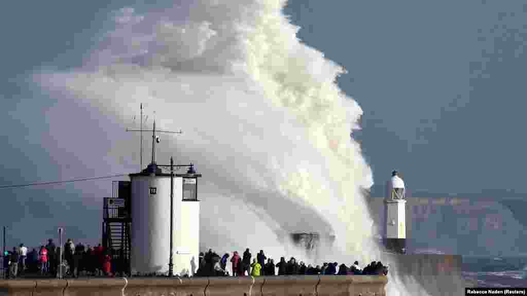 Ozalky Atlantika, häzirki Ophelia tupany Porskawldan, Walesden geçip, çyraly jaýyň üstünden aşýar. 16-njy oktýabr.&nbsp; (Reuters/Rebecca Naden)