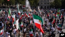 Demonstranti drže zastave dok se okupljaju na Trafalgar skveru u Londonu 16. septembra 2023, na obeležavanju godišnjice smrti Mahse Amini u Iranu.