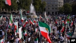 Demonstrators wave Iranian flags as they gather in Trafalgar Square, London, Saturday, on September 16.
