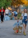 Місцеві жителі йдуть за водою до автоцистерни в окупованому Донецьку, 21 серпня 2025 року