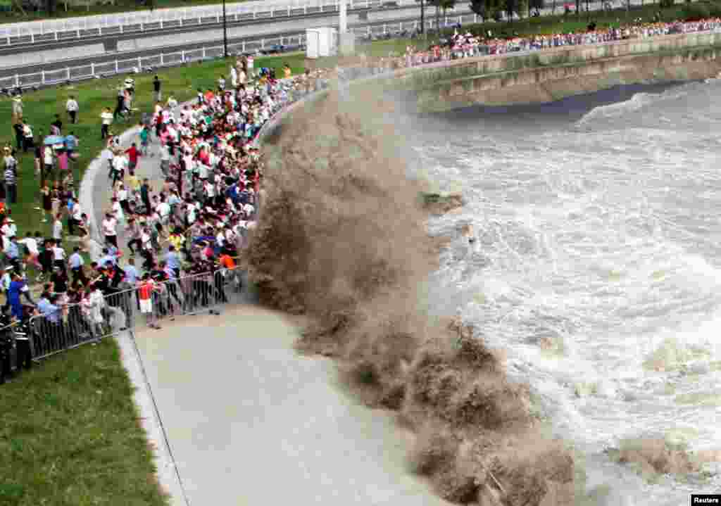 People run away from waves as they watch the tidal bore in Hangzhou, Zhejiang Province, China. (Reuters)