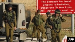 Израильские солдаты на одном из въездов в деревню Ятта на Западном берегу Иодана, 9 июня 2016 года