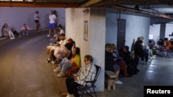 People take shelter inside an underground parking garage in Kyiv during Russian missile and drone strikes on July 6.