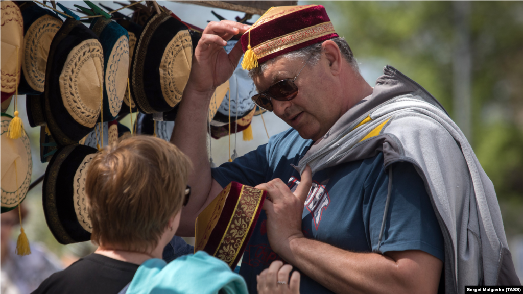 Туристы выбирают головные уборы у крымскотатарской&nbsp;сувенирной лавки&nbsp;