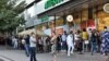 People wait in line outside a pharmacy in Almaty, Kazakhstan, on June 29.