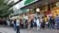 People wait in line outside a pharmacy in Almaty, Kazakhstan, on June 29.