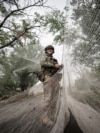 Військовослужбовець 24-ї механізованої бригади імені короля Данила Збройних сил України встановлює протидронові сітки над дорогою