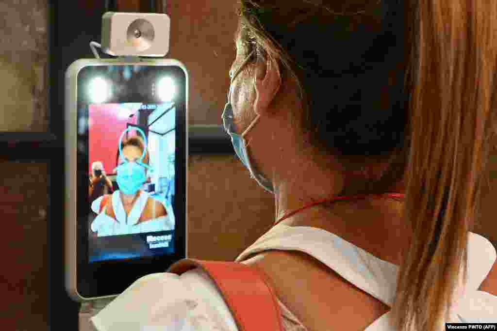 A teacher undergoes a body-temperature scan as she arrives for the start of the school year at the Luigi Einaudi High School in Rome, during the the COVID-19 pandemic on September 14.