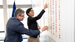 Comisara europeană pentru Extindere, Marta Kos, și spicherul moldovean, Igor Grosu, într-o fotografie difuzată de parlamentul moldovean, numărând reformele pe o tablă, la Bruxelles, pe 17 martie 2026 