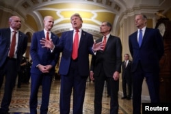U.S. President Donald Trump speaks to reporters next to US senators on Capitol Hill in Washington on June 24.