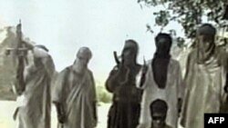 Jundallah militants stand over a blindfolded and kneeling kidnapped Iranian security worker, in footage broadcast by Al-Arabiyah in June 2000.