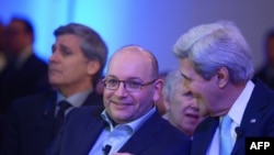 Freed Washington Post Tehran bureau chief Jason Rezaian (C) chats with US Secretary of State John Kerry during the inauguration of the Washington Post Headquarters on January 28, 2016 in Washington, DC.