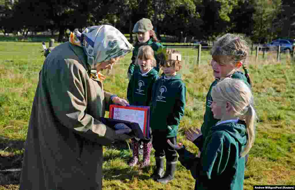 Королева Єлизавета II з дітьми з початкової школи Крейті в павільйоні крикету, Балморал, Шотландія, 1 жовтня 2021 року