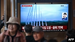 ადამიანები უყურებენ ტელევიზორის ეკრანს, რომელზეც ნაჩვენებია  ჩრდილოეთ კორეის რაკეტის გამოცდა. კადრები არქივიდანაა. 