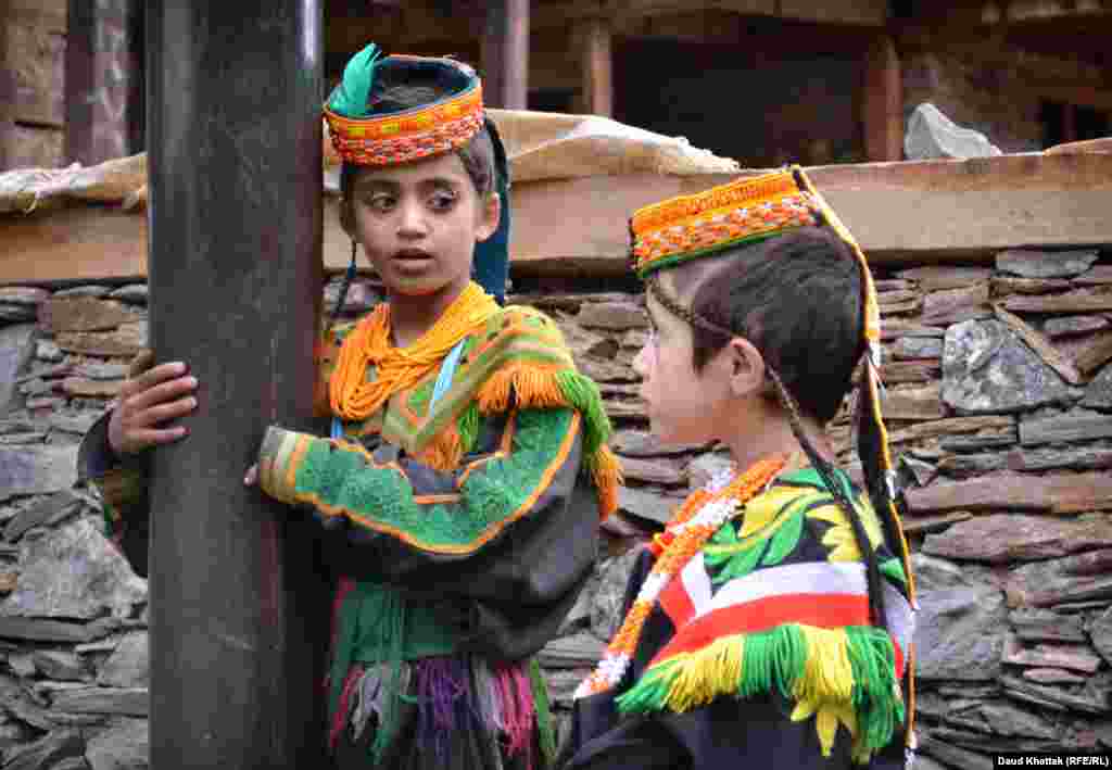 Kalash friends chatting inside a village. The Kalash religion is a complex mix of ancient customs, and includes a belief in fairies who flit through the high mountain peaks before settling onto the alpine meadows in autumn.