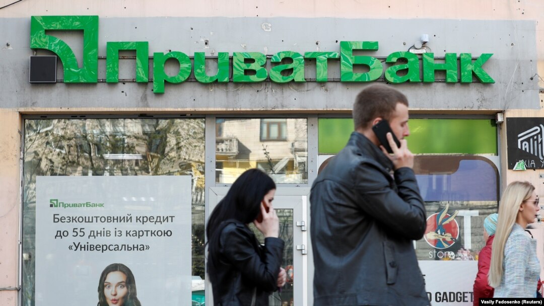People walk past a branch of PrivatBank, the country's biggest lender, in Kyiv.