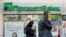 People walk past a branch of PrivatBank, the country's biggest lender, in Kyiv.