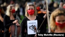 Zenészek adnak elő 2020. október 6-án a Westminster-palota közelében, hogy így tiltakozzanak, amiért nem tudnak fellépéseket tartani és dolgozni a koronavírus-járvány miatt.