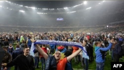 Dnipro Dnipropetrovsk's fans storm the field in celebration after their team's semifinal match against Napoli in Kyiv on May 14.