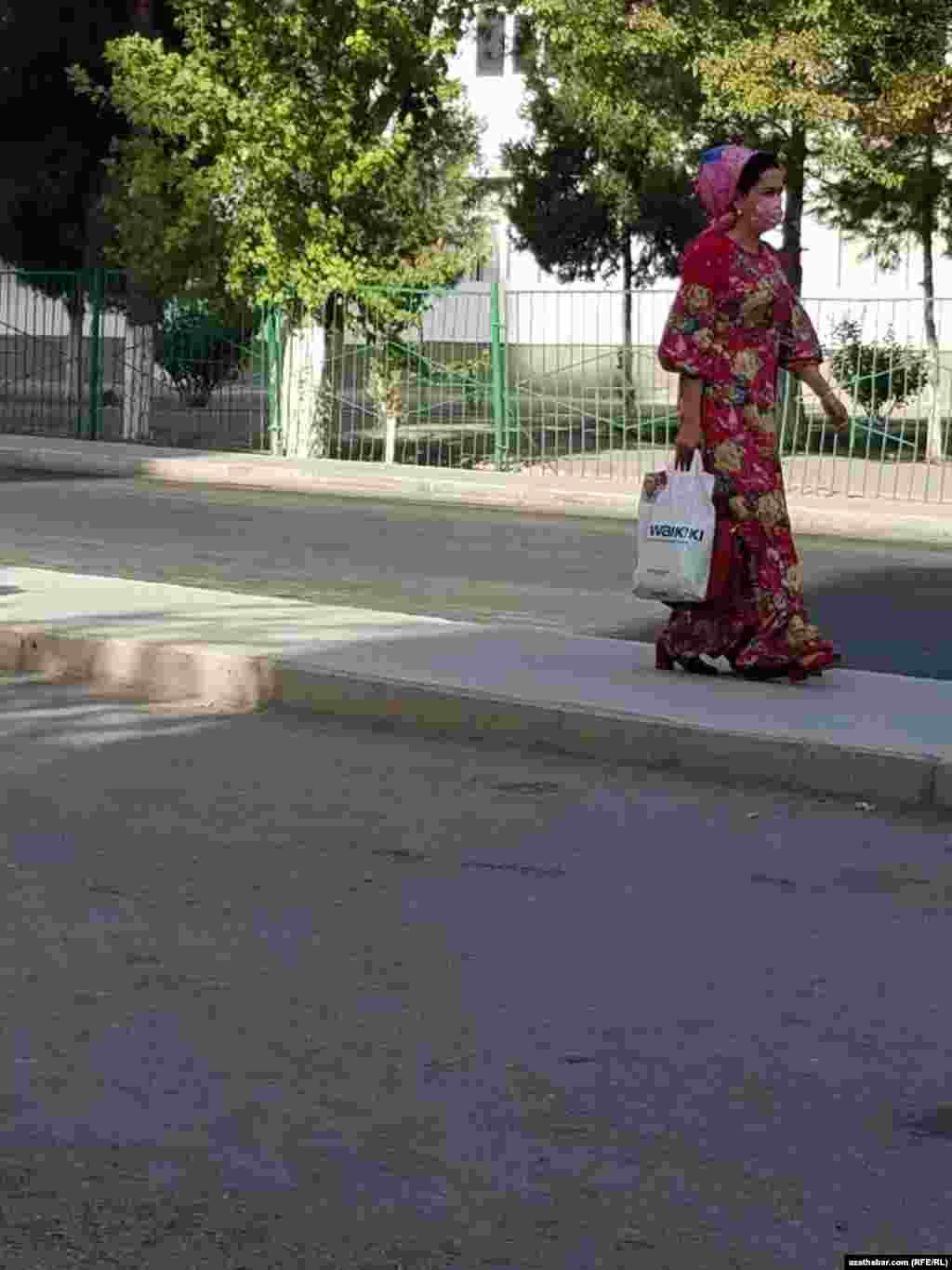 Gülgüne köýnekli, gülgüne ýaglykly we gülgüne maskaly zenan. Aşgabat, 2021.&nbsp;