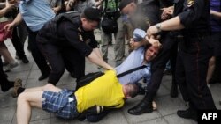 Полиция разнимает православного активиста и активиста гей-движения, сцепившихся у здания Госдумы в Москве. 13 июня 2013 года