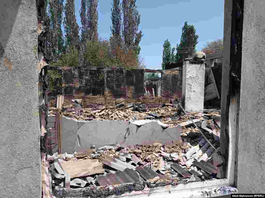 Обломки уничтоженного жилого здания видны в оконном проеме.&nbsp;