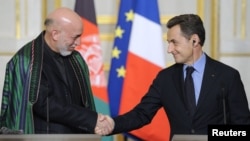 French President Nicolas Sarkozy (right) and Afghan President Hamid Karzai shake hands at a news conference after talks and a treaty signing at the Elysee Palace in Paris on January 27.