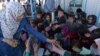 FILE: A UN aid worker distributes pens to Afghan refugee children upon their return to Afghanistan from Pakistan.