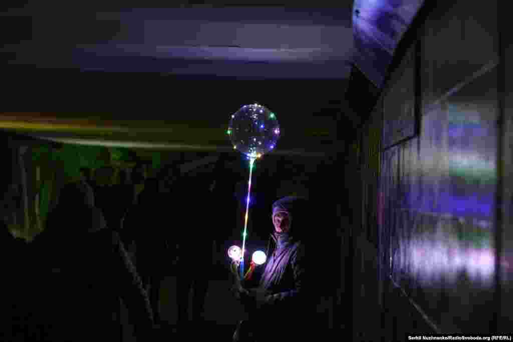 Жінка продає ліхтарики й повітряні кульки з LED-підсвіткою в підземному переході під час вимкнення електроенергії. Київ, 20 грудня 2025 року