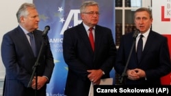 Former Polish Presidents Aleksander Kwasniewski (left) and Bronislaw Komorowski (center) and Ukraine's ambassador to Poland, Andriy Deshchytsia, speak to reporters in Warsaw on May 28.