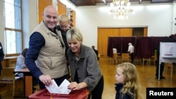 Premierul leton Andris Kulbergs exprimându-și votul, cu familia, la Riga, pe 3 octombrie. 