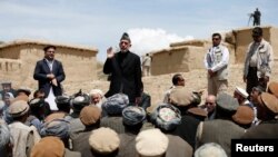 Afghanistan -- President Hamid Karzai (2nd L) speaks to displaced villagers during his visit at the site of a deadly landslide in the Argo district of Badakhshan province, May 7, 2014