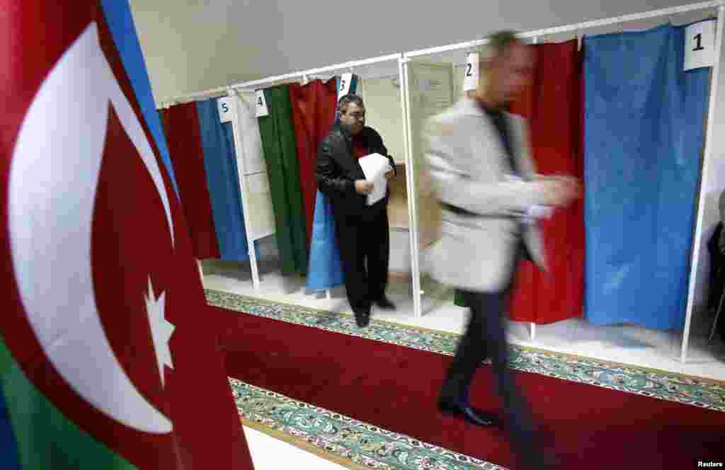 People leave the voting booths during the presidential election at a polling station in Baku.