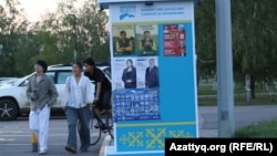 Молодежь на фоне предвыборного стенда в Астане

